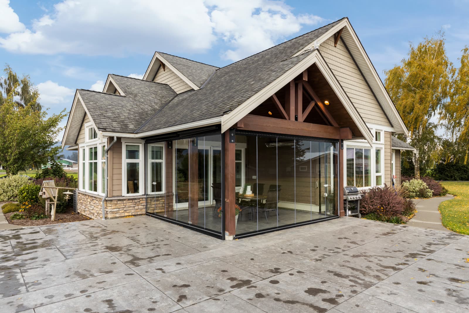 Custom timber-frame sunroom with full glass enclosure and gabled roof, integrated into a Fraser Valley home