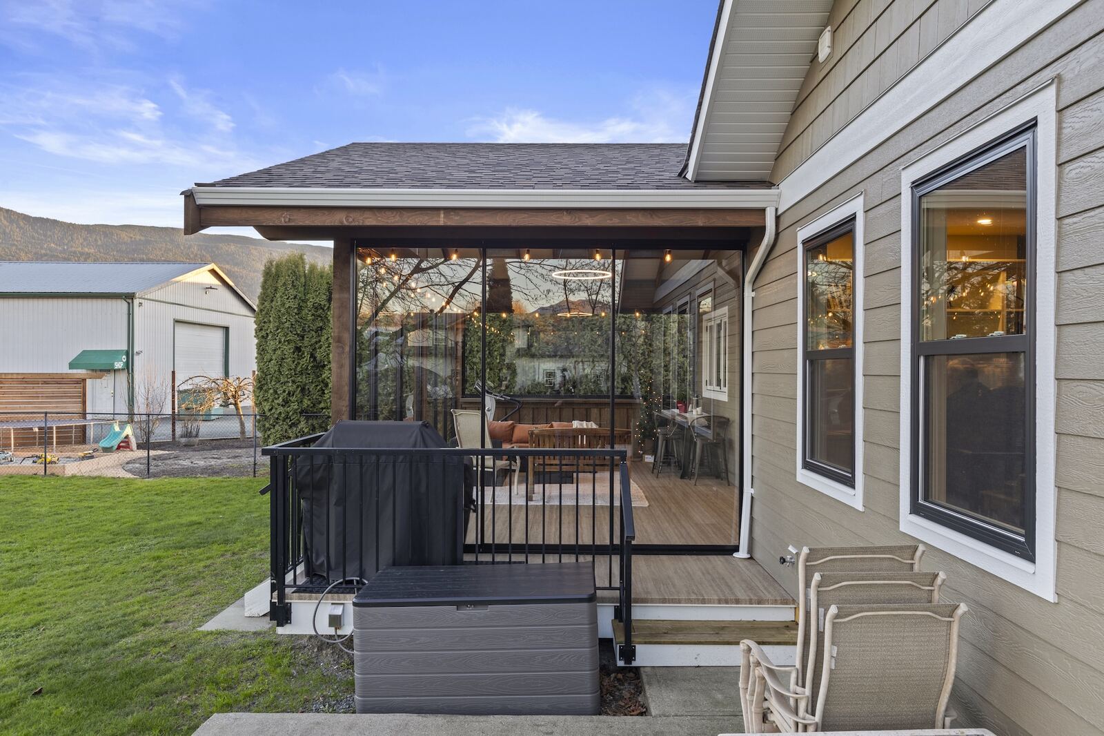 Exterior view of a Fine Line sunroom addition with a covered patio, integrated into the home's roofline